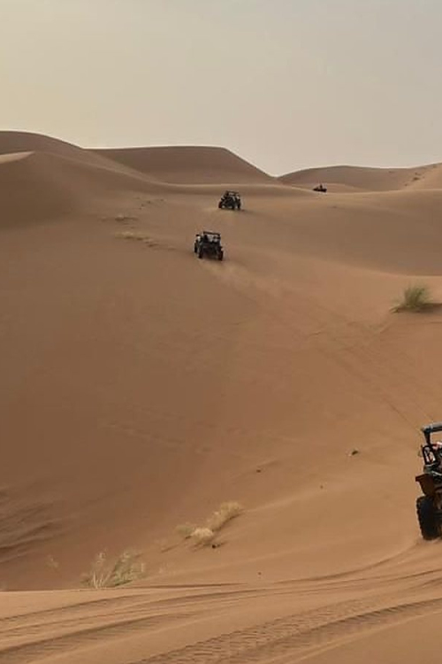 Buggy traversant une immense etendue de dunes de l'erg dans le desert marocain
