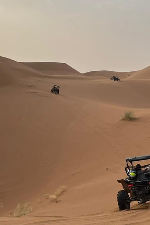 Buggys progressant en file sur un cordon de dunes du desert du Sud marocain